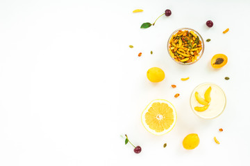Healthy breakfast with fresh fruit, apricot, nuts, arugula, grapefruit, granola, cherry on white background. Flat lay, top view