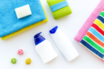 Bath accessories. Towels, soap, shampoo, washclothes on white background top view copyspace