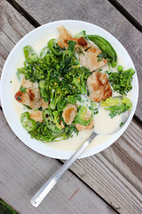 Nutritious dish of roasted pork fillet, green pepper, greens, broccoli in cream
