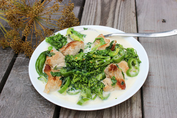 Nutritious dish of roasted pork fillet, green pepper, greens, broccoli in cream