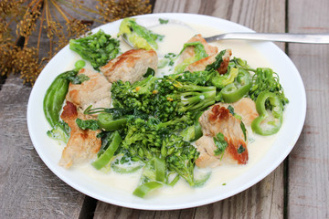 Nutritious dish of roasted pork fillet, green pepper, greens, broccoli in cream