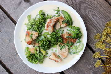 Nutritious dish of roasted pork fillet, green pepper, greens, broccoli in cream