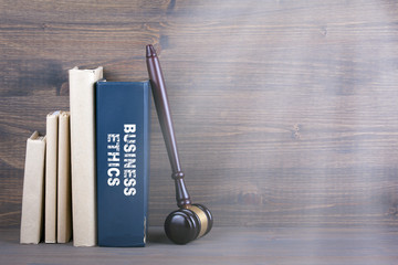 Business Ethics. Wooden gavel and books in background. Law and justice concept.