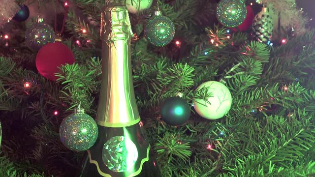New suitable bottle of champagne against the background of decorated with toys and a garland of a Christmas fir-tree