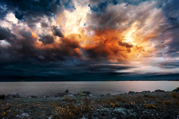 Fantastic sunset clouds on the background of the sea and the coast