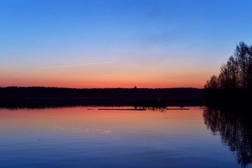 the evening lake water surface in the backdrop of the setting red sun blue background nature wallpaper