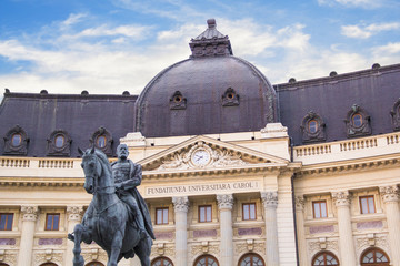 Beautiful view of the building of the Central University Library with equestrian monument to King Karol I in front of him in Bucharest, Romania - obrazy, fototapety, plakaty