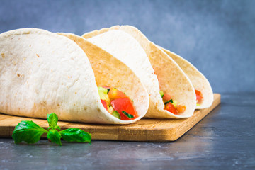 Traditional Mexican tacos with meat and vegetables on wooden background