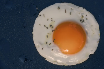 Closeup of fried eggs on a black background. top view