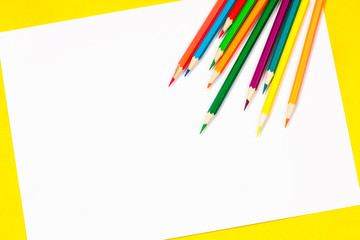Fototapeta premium School supplies and white sheet on a bright yellow background, ready for your design