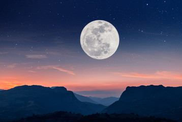 Fototapeta na wymiar Atardecer en la montaña con luna llena