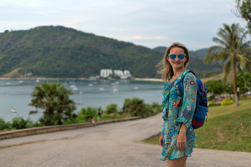 Portrait of a girl in sunglasses and a tunic of the sea and the jungle