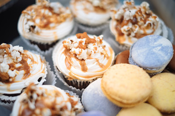 Fresh baked macaroon pastry cookies macarons, macaroni and cupcakes with caramel cream. Candy bar for birthday patry celebration, childhood, shallow focus. Sweet table - desserts, macaroni, cake