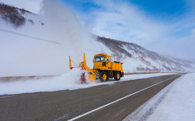 Snowplow truck (Snow removal truck) is removing the snow from the highway during a cold snowstorm...