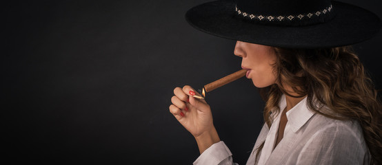 Portrait of sexy elegant lady woman with hat smoking cigar