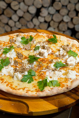 Gourmet goats cheese, mozzarella and truffle pizza served on a rustic wooden board