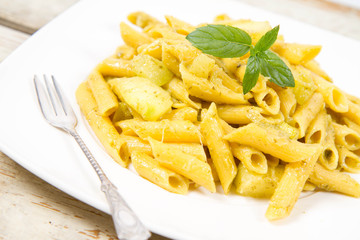 Penne with pesto and zucchini decorated with mint