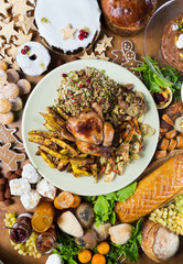 Unique beautiful christmas meal platter, with roast chicken and vegetables, surrounded by cakes,...