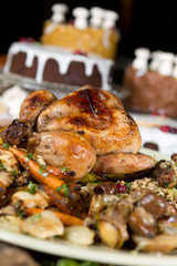 Unique beautiful christmas meal platter, with roast chicken and vegetables, surrounded by cakes, mince pies, fruit, bread and jam.