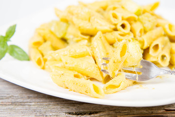 Penne with pesto and zucchini decorated with mint