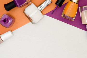 Bottles of nail polish. Orange, purple and white color. © devmarya