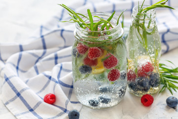 Berries and tarragon in jar with sparkling ice water.