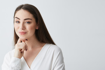 Young beautiful playful businesswoman with cunning tricky glance smiling looking at camera over white background.