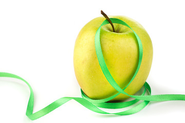 Bright ripe yellow apple and green ribbon
