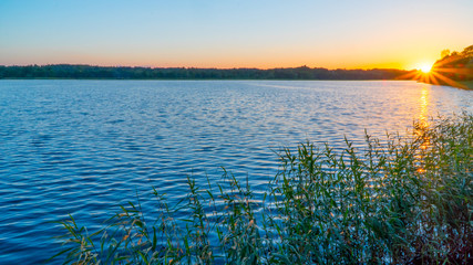 beautiful sunset on the lake, fishermen on the boat.