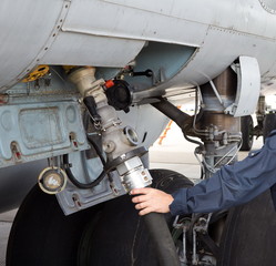 Fototapeta premium The process of refueling airplane in airport. Fuel hose is inserted