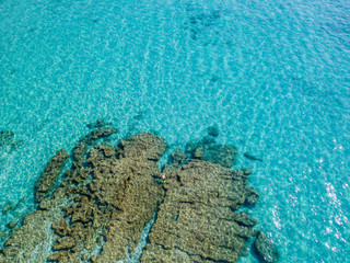 Vista aerea di scogli sul mare. Panoramica del fondo marino visto dall&rsquo;alto, acqua trasparente. Nuotatori, bagnanti che galleggiano sull&rsquo;acqua