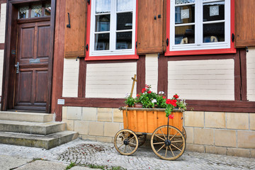 Fototapeta na wymiar Bollerwagen vor Fachwerkhaus in der Altstadt von Halberstadt