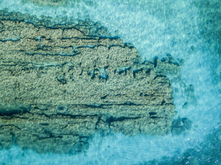 Vista aerea di scogli sul mare. Panoramica del fondo marino visto dall’alto, acqua trasparente