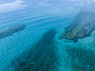 Vista aerea di scogli sul mare. Panoramica del fondo marino visto dall’alto, acqua trasparente
