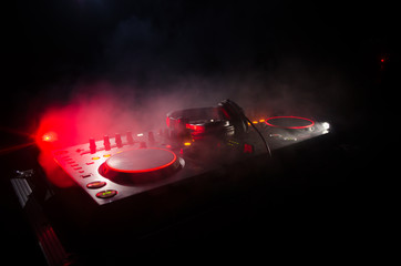 DJ Spinning, Mixing, and Scratching in a Night Club, Hands of dj tweak various track controls on...