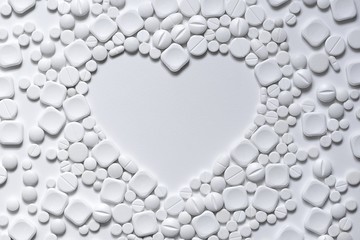 Heart of white pills on a white background