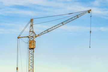 Old abandoned tower crane on a sky background