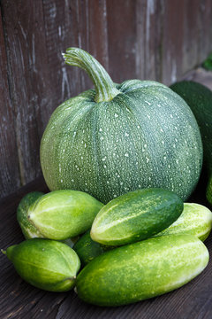 Fresh zucchini and cucumbers on the wooden table. Bio vegetables on a wooden background.