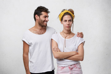 Unhappy young female wearing yellow headband having upset mad look, holding arms crossed while...