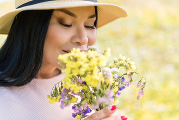 Relaxed lady enjoying scent of wildflowers
