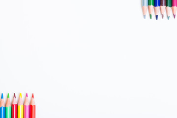 On white background colored pencils. White field for text. The tips of the pencils on a light background.