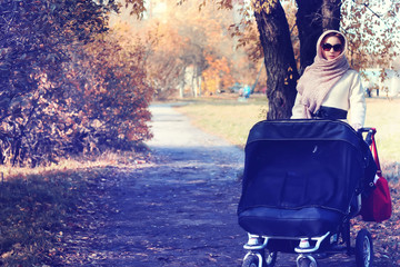 mother in a park stroller autumn