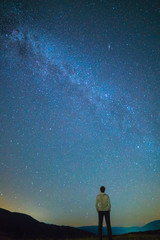 The man stand and look to the starry sky. night time