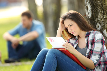 Fototapeta premium Sad student looking at failed exam