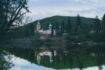 Fototapeta na wymiar Northern front of Lillafured palace in Miskolc, Hungary. Lake Hamori in foreground with reflections. Travel outdoor landmark background