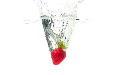 Strawberry falling in the water with splash, isolated on a white background