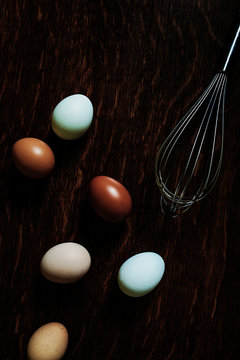 multi coloured organic eggs and whisk