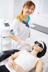 Woman having legs Laser hair removal epilation in cosmetic salon