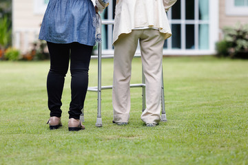 Fototapeta premium Elderly woman exercise walking in backyard with daughter