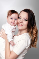 newborn baby in a tender embrace of mother at the window